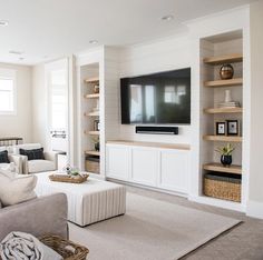 a living room filled with furniture and a flat screen tv mounted on the wall above it