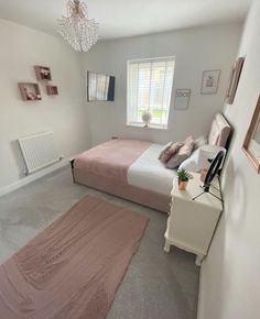 a bed room with a neatly made bed and a rug