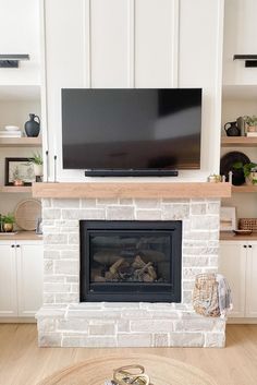 a fireplace with a flat screen tv above it and shelves on the wall behind it