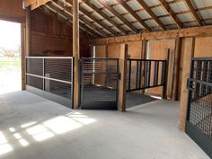 the inside of a barn with stalls and gates