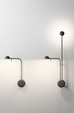 three lights are hanging on the wall next to each other in an empty room with white walls