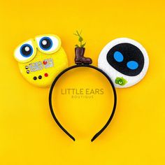 two little ears headbands with eyes and nose designs on them, against a yellow background