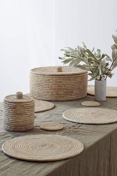 the table is covered with woven baskets and placemats, along with a potted plant