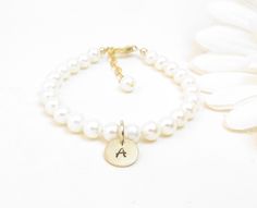 "Freshwater Pearl Bracelet with Gold-Filled Initial for ages newborn up to teen: Created with Grade-A 5.5mm round freshwater pearls, a 14K gold-filled oval lobster clasp and a 14K gold-filled disc hand stamped with one initial. Includes a sturdy 14K gold-filled \"Grow with Me\" extender chain. All metal components are 14K gold-filled. The initial disc charm is 3/8\" round with a high-quality heavy gauge thickness. The letter can be left unoxidized for a more subtle look (by request). Arrives pac Classic Adjustable White Name Bracelet, Classic White Adjustable Name Bracelet, Personalized White Pearl Bracelet For Baptism, Adjustable Personalized Pearl Bracelet For Baptism, Real Pearl Bracelet, Real Pearl Earrings, White Pearl Jewelry, Initial Earrings, Moms Bracelet