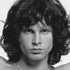 black and white photograph of young man with long curly hair wearing a necklace on his neck