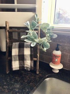 a bathroom sink with a towel rack and soap dispenser next to it