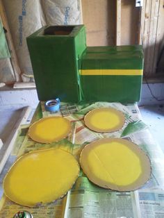 four yellow pies sitting on top of a table next to green boxes and papers