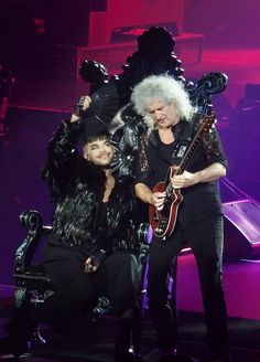 two people on stage with one holding an electric guitar