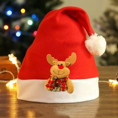 a red and white christmas hat with a reindeer on it's side sitting on a table