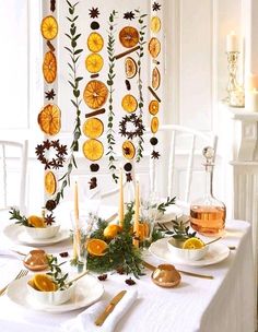 the table is set with orange slices and greenery for an elegant dinner party setting