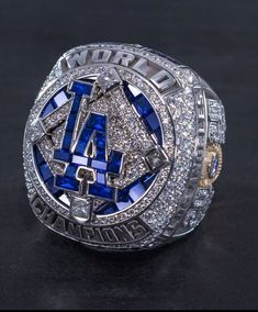 the los angeles dodgers world series ring is displayed on a black surface with white and blue diamonds