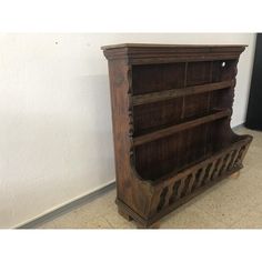 an old wooden bookcase sitting against a wall