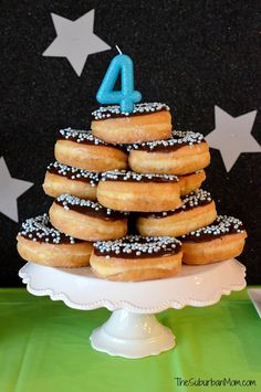 a birthday cake made to look like donuts on a plate with the number four