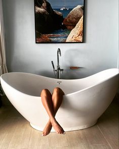 a woman sitting in a bathtub with her legs crossed