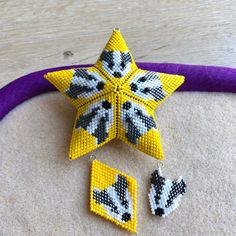 a yellow and black beaded star ornament next to two earrings