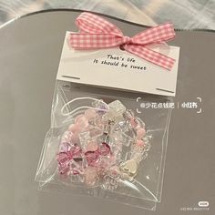 a glass table with some pink and white items on it's display case, along with a card saying that there's life is should be sweet