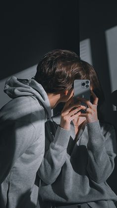 a person taking a selfie in front of a mirror with their cell phone up to their face