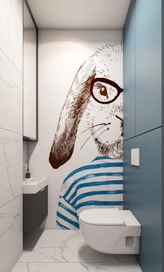 a bathroom with a rabbit painted on the wall next to a white toilet and sink