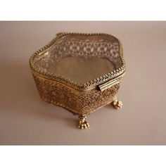 an ornately decorated metal box with gold trimmings on the sides and feet