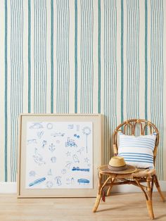 a chair next to a wall with a blue and white striped wallpaper behind it