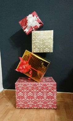 three wrapped presents are stacked on top of each other in red and gold wrapping paper