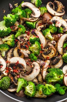 mushrooms and broccoli are cooking in a wok