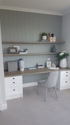 a chair and desk in a room with shelving on the wall behind it,