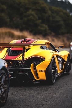 two sports cars parked next to each other on the road