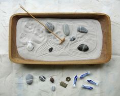 a wooden tray filled with rocks and sand