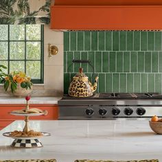 a stove top oven sitting inside of a kitchen next to a bowl filled with fruit