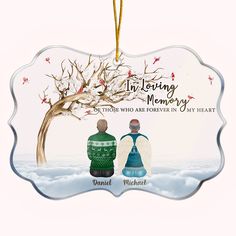 an ornament with two people sitting under a tree and the words in loving memory