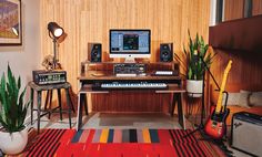 a living room filled with lots of furniture and musical equipment on top of a rug