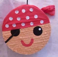 a paper plate with a pirate face on it and a red bow around its neck