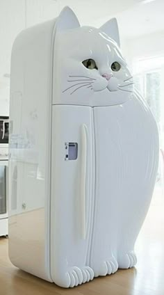 a white cat shaped refrigerator sitting on top of a wooden table