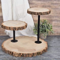 two tiered wooden trays with black metal legs and wood slices on the sides