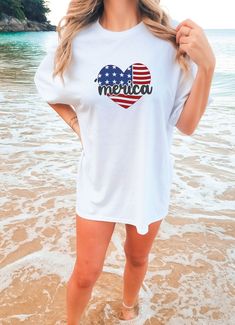 Merica Heart Comfort Colors Tee | 4th of July Tshirt | America Shirt | Oversized Summer Tee | Trendy Beach Clothes | Independence Day DETAILS: Comfort Colors 1717 SIZES: Small-2X SIZE GUIDELINES: This Comfort Colors Shirt is a unisex fit that runs TRUE to size! If you want this to be comfortably fitted (NOT oversized), I recommend sticking with your regular size! -If you want it to fit slightly oversized, I recommend sizing up 1 size! -If you want it to fit very oversized (like the pictures), I recommend sizing up 2-3 sizes! Please allow 3-8 business days processing time for your item to be handmade just for YOU! All orders will ship via either USPS or UPS from Louisiana. Summer Flag Print T-shirt With Relaxed Fit, Summer Tops With Heart Graphic And Crew Neck, American Flag Print Cotton Top For Beach, Cute American Flag Print T-shirt For Summer, White American Flag Print Top For The Beach, White American Flag Print Top For Beach, White Tops With American Flag Print For Beach, White American Flag Print Tops For Beach, Summer White Shirt With Heart Graphic