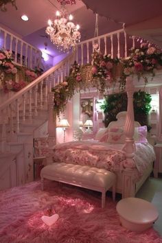 a bedroom decorated in pink and white with lots of flowers on the bed, chandelier