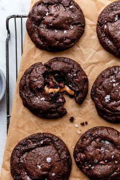 chocolate cookies with sea salt and caramel are on a baking sheet next to a cup of coffee