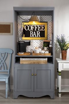 a gray cabinet with a sign that says coffee bar on the front, and a blue chair next to it