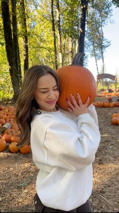 a woman holding a pumpkin in her hands