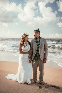 a newly married couple standing on the beach