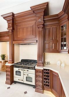 a kitchen with wooden cabinets and an oven in the center, along with white tile flooring