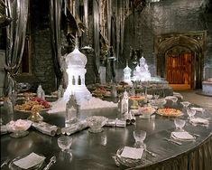 an elaborately decorated table in a castle like setting with silverware and plates on it