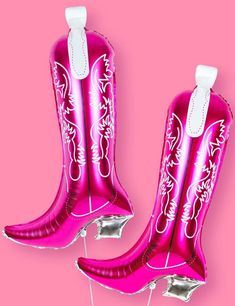 two pink cowboy boots are shown on a pink background with balloons attached to the legs