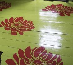 the floor is painted with red and white flowers on yellow wood planks as if it were an art installation