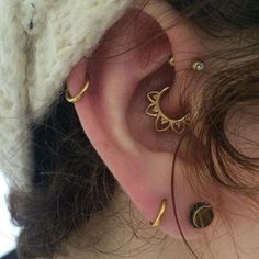 a close up of a person's ear with three different piercings on it