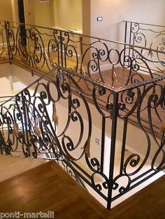 an iron stair railing in a house with wood floors