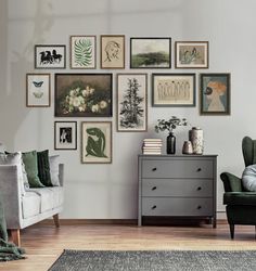 a living room filled with furniture and framed pictures on the wall above a gray dresser