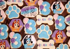 decorated cookies with cartoon characters are displayed on a wooden table in the shape of letters and numbers