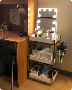 a desk with a mirror, drawers and lights on it in an office space next to a chair